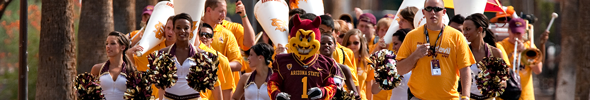 ASU students, marching band members, cheerleaders, and Sparky the Sun Devil walking down Palm Walk